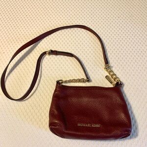 Small maroon Michael Kors crossbody bag.